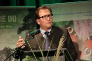 Mann mit Brille und Janker am Rednerpult