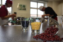 Beeren lieben auf einem Tisch, dahinter Gläser mit gelbem und schwarzem Inhalt